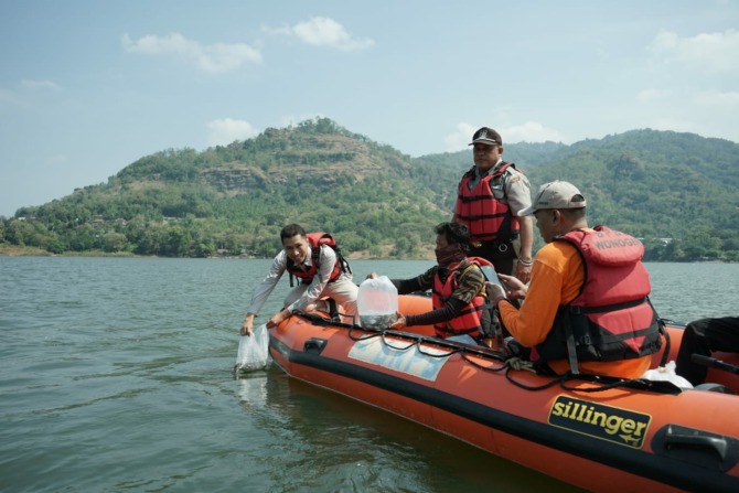 Tebar benih ikan di Waduk Gajah Mungkur belum lama ini. (IWAN ADI LUHUNG/RADAR SOLO)