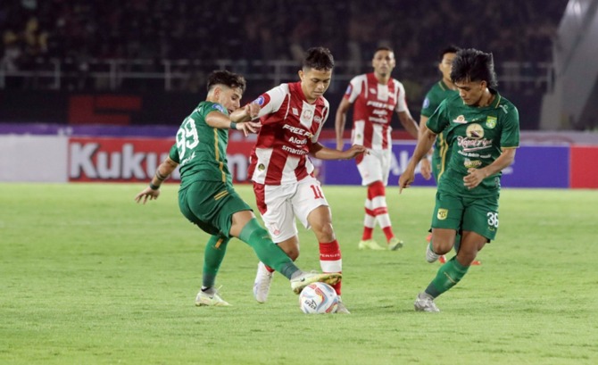 SULIT BERGERAK: Gelandang Persis Solo Arapenta Poerba dikawal dua pemain Persebaya Surabaya di Stadion Manahan (1/7/2023). (M. IHSAN/RADAR SOLO)