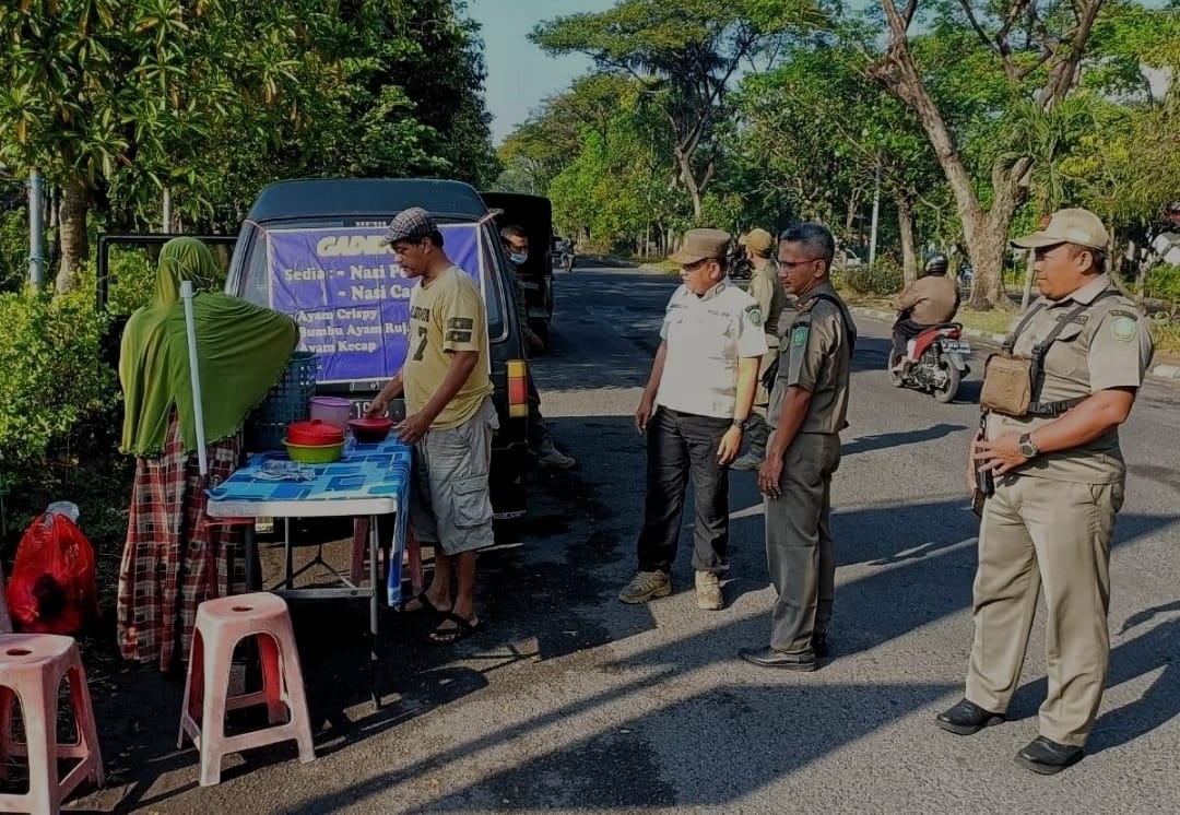 DITERTIBKAN: Petugas Satpol PP saat menertibkan PKL yang berjualan di tepi jalan. (IST)