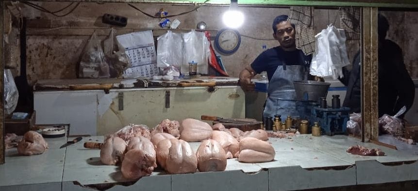 MELAMBUNG: Muhammad Imam menjual daging ayam di Pasar Wadungasri. (DIKY PUTRA SANSIRI/RADAR SIDOARJO)
