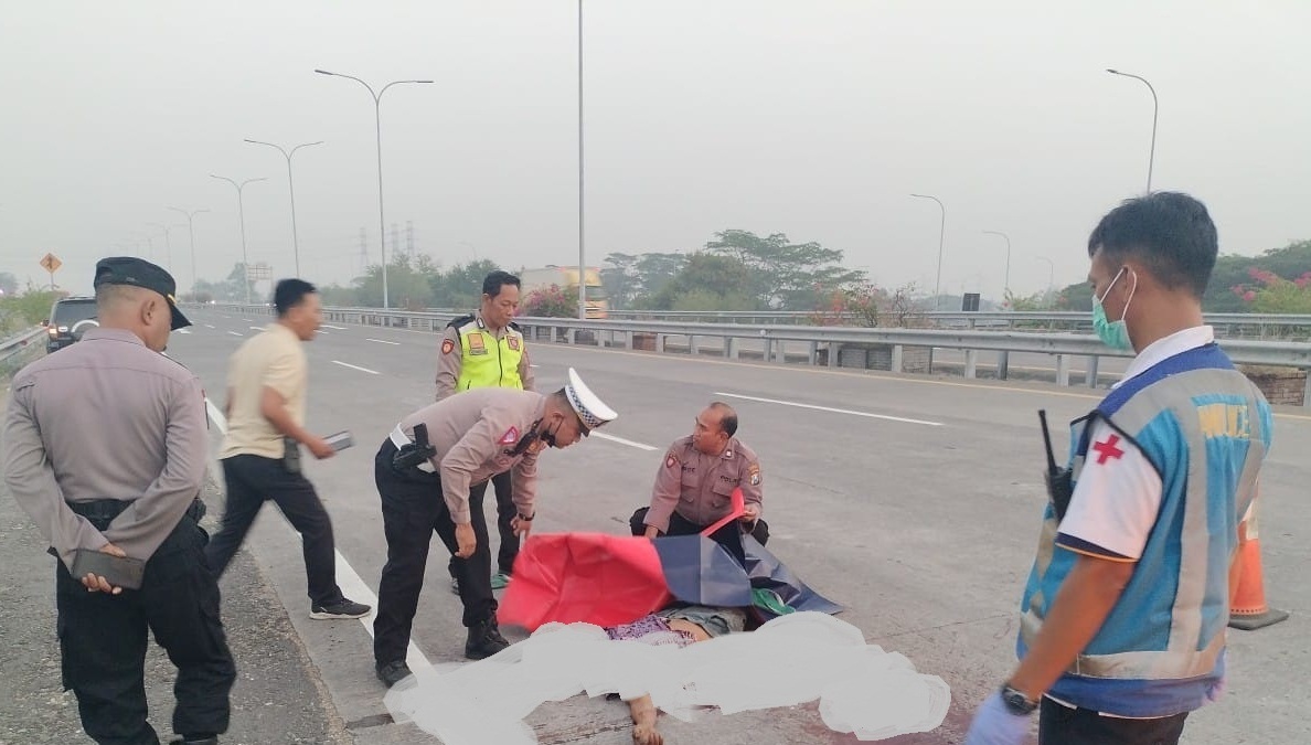 MISTERIUS: Petugas menemukan mayat yang tergeletak di Jalan tol Surabaya-Mojokerto KM 745. (IST)