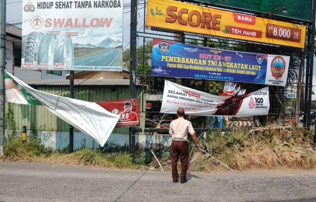PENERTIBAN: Tim dari BPPD Sidoarjo menurunkan reklame yang sudah melewati masa pajak. (IST)