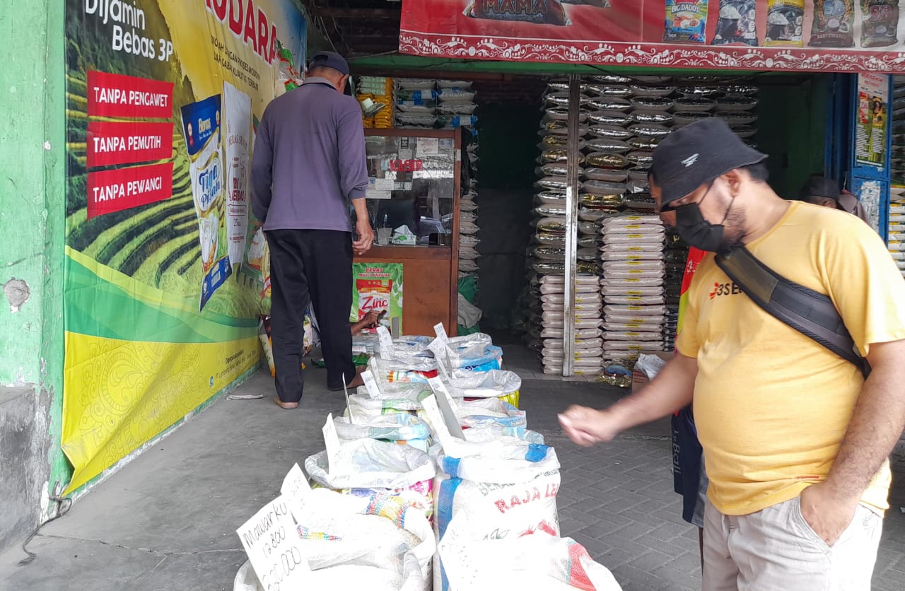 MAHAL: Seorang pembeli melihat beras di Pasar Larangan. (M SAIFUL ROHMAN/RADAR SIDOARJO)