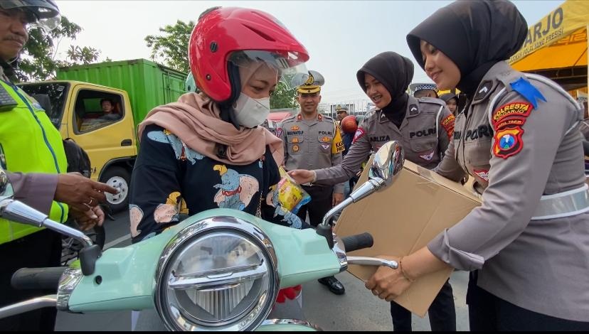 BERUNTUNG: Polwan memberikan sembako kepada pengguna jalan yang tertib berlalu lintas. (IST)