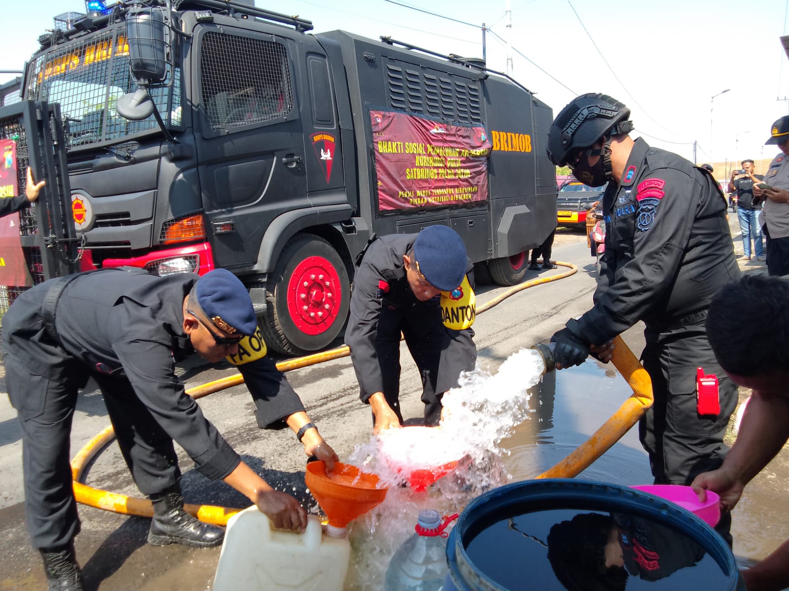 PEDULI: Brimob Porong berikan bantuan air bersih untuk warga terdampak lumpur. (DIKY PUTRA SANSIRI/RADAR SIDOARJO)