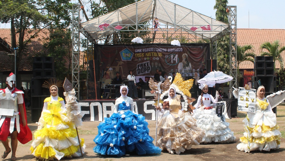 Para siswa SMKN 1 Jabon menampilkan kreasi dari bahan daur ulang dalam karnaval Dies Natalis ke-14. (ANAS/RADAR SIDOARJO)