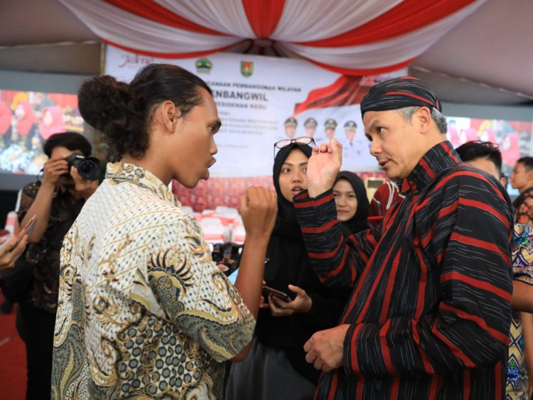 COBA MEMAHAMI: Ganjar Pranowo berbincang dengan Iqbal, penyandang tuna rungu asal Temanggung saat berada di Pendapa Kabupaten Magelang. (Foto: Humas Pemprov Jateng)