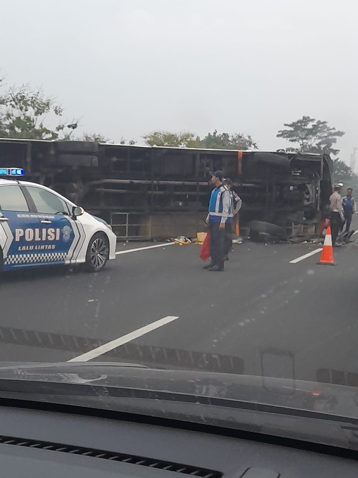 MACET: Kondisi bus yang terguling di Jalan Tol Sidoarjo arah Porong. (Ist)