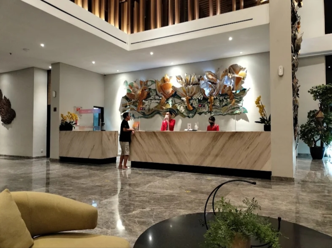BERSIAP: Seorang pengunjung sedang mendatangi meja resepsionis salah satu hotel di Sidoarjo. (Ist)