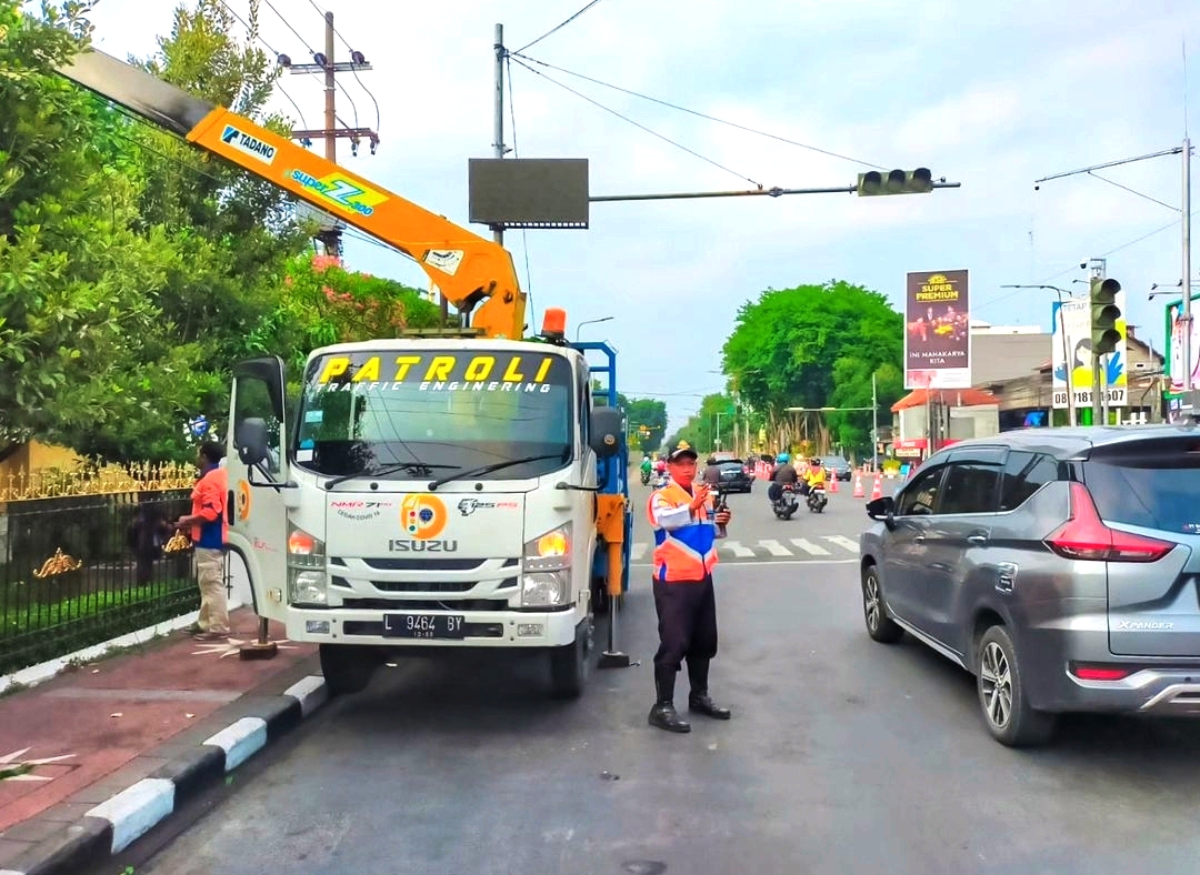 RUSAK: Petugas Dishub Sidoarjo melakukan perbaikan TL yang rusak di Jalan Ahmad Yani. (IST)