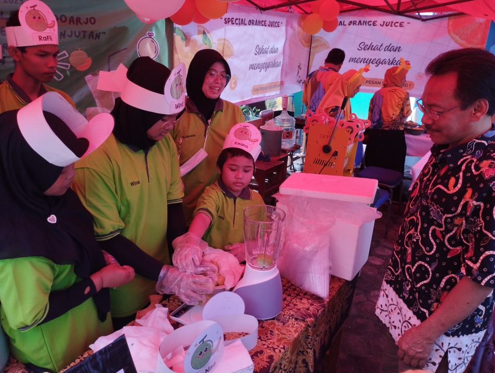 BELAJAR MANDIRI: Salah satu siswa membuat minuman jus melon dengan bimbingan guru SLB C Dharma Wanita Lebo, Sidoarjo. (ANNISA FIRDAUSI/RADAR SIDOARJO)
