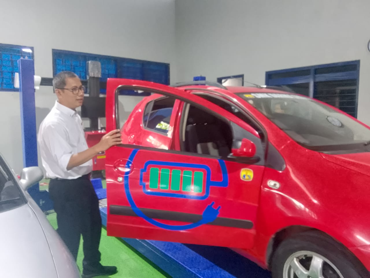 KREATIF: Kepala SMK Darma Siswa 1 Sidoarjo H. Argo Ciptono, S.T, M.M. mencoba menaiki mobil listrik. (DIKY PUTRA SANSIRI/RADAR SIDOARJO)