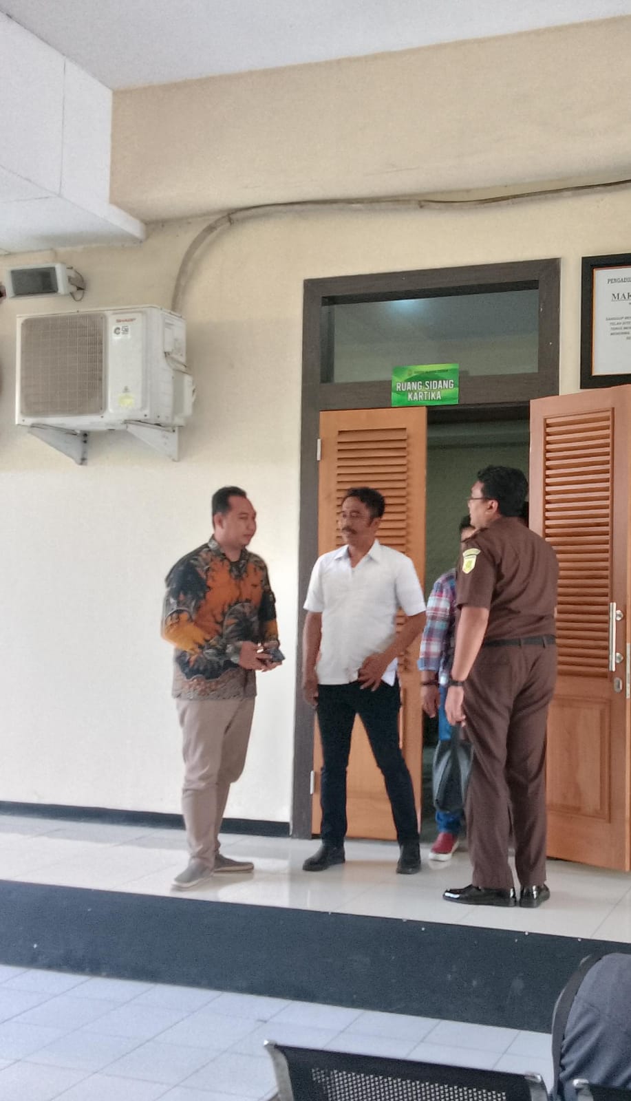 TERDAKWA : Kepala Desa Tarik Ifanul Ahmad Irfandi (kiri) usai menjalani sidang perdana. (DIKY PUTRA SANSIRI/RADAR SIDOARJO)