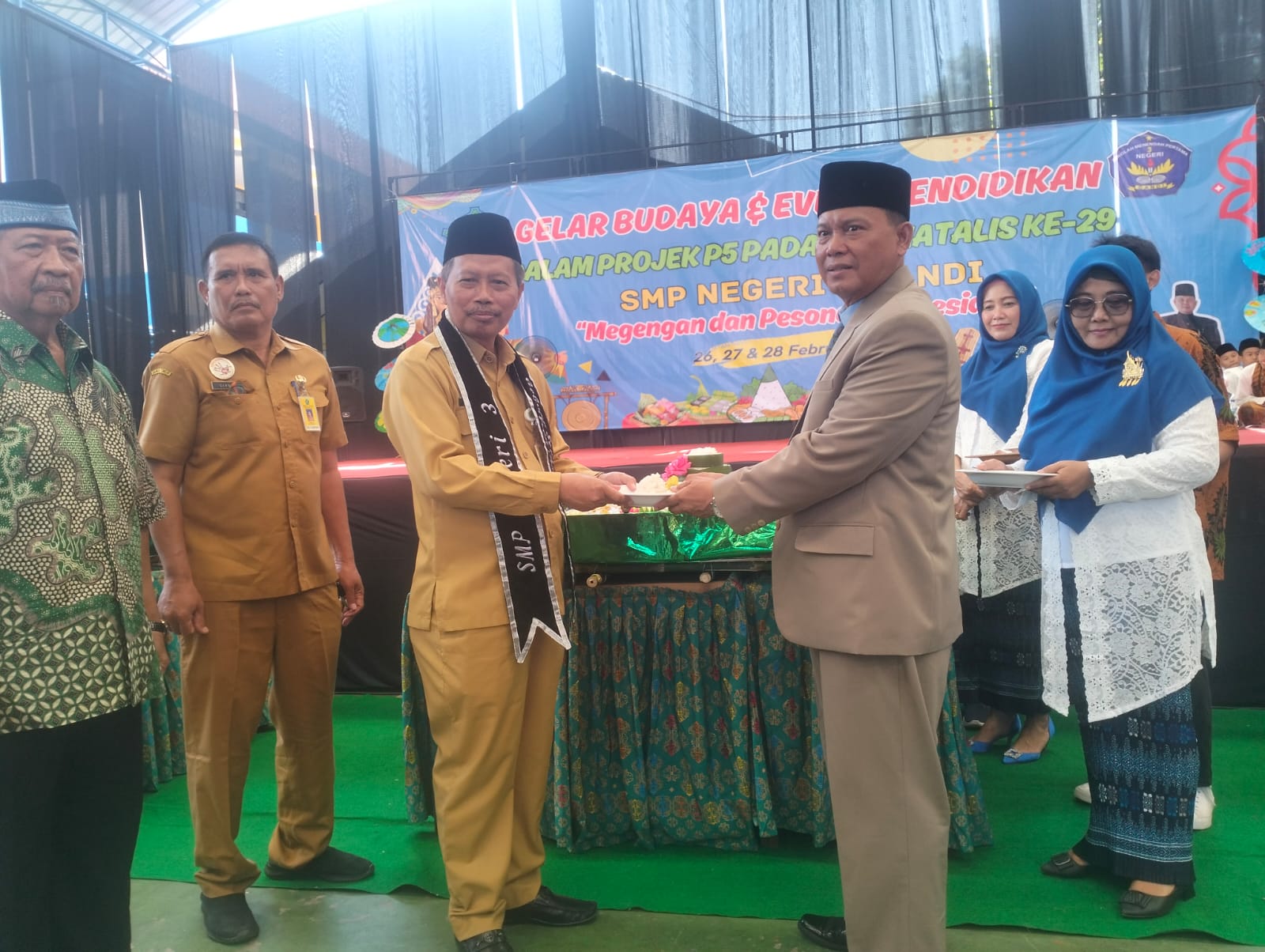APRESIASI: Kepala Dinas Pendidikan dan Kebudayaan Sidoarjo Dr Tirto Adi saat motong tumpeng diberikan ke Kepala SMPN 3 Candi Gufron, S.Pd, M.Pd. (ANAS/RADAR SIDOARJO)