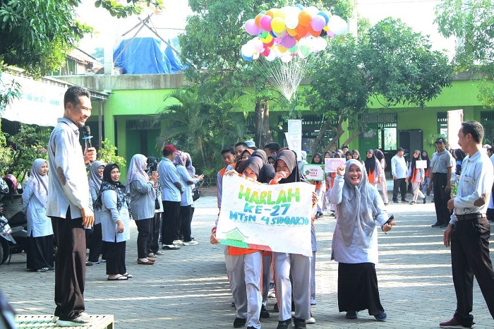 SEHAT: Kepala MTsN 4 Sidoarjo Ahmad Mujahidin (kiri) saat memberangkatkan jalan sehat dalam kegiatan Ulang tahun MTsN 4 Sidoarjo yang ke-27. (ANAS/RADAR SIDOARJO)