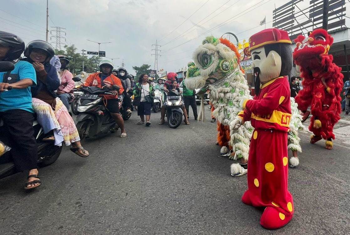 HIBURAN: Keseruan bagi-bagi takjil oleh umat Tionghoa beserta hiburan barongsai. (M SAIFUL ROHMAN/RADAR SIDOARJO)