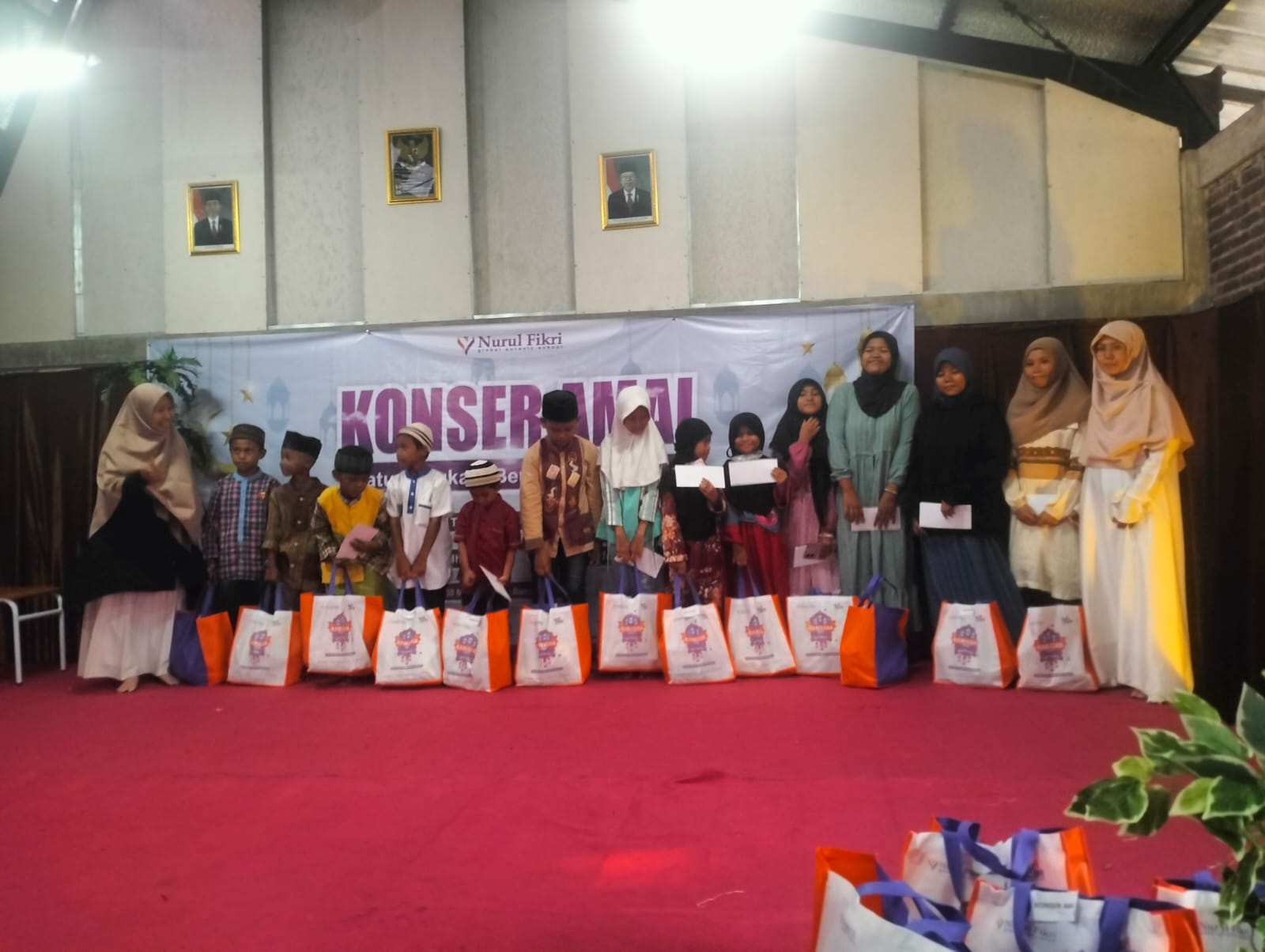 BERBAGI: Perwakilan salah satu guru SMP Nurul Fikri Sidoarjo saat memberikan santunan anak yatim dalam kegiatan konser amal. (ANAS/RADAR SIDOARJO)