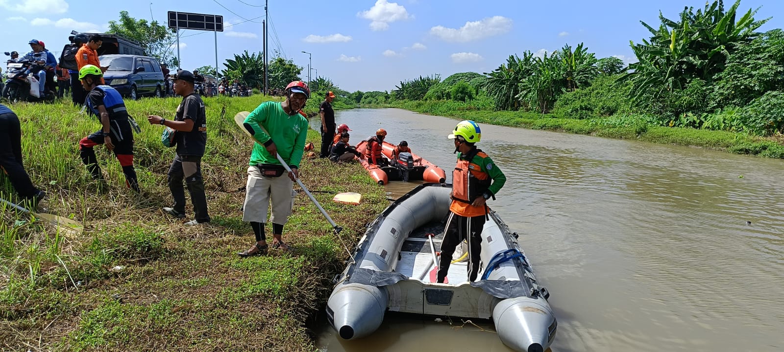 PENCARIAN : Tim BPBD dan Polsek Tarik sedang berada di lokasi terceburnya pengendara motor di sungai Tarik, Minggu, 28 April 2024. (IST)
