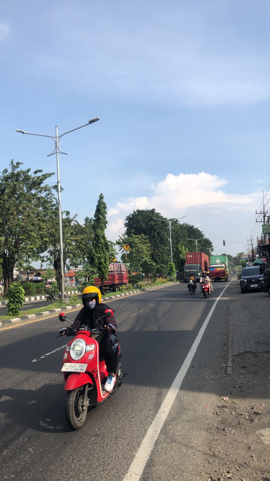 PERLINDUNGAN MAKSIMAL: Pengendara sepeda motor yang melintas di Jalan Gedangan, Sidoarjo, saat cuaca panas. (JULIANTI LESTARI/RADAR SIDOARJO)