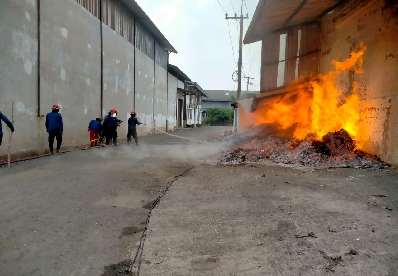 SI JAGO MERAH: Petugas Damkar berupaya memadamkan api di gudang wilayah Gedangan, Minggu (5/5). (DIKY PUTRA SANSIRI/RADAR SIDOARJO)
