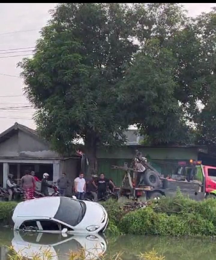 APES : Honda Brio terperosok di Sungai Sukodono, Senin (6/5) pagi. (IST)
