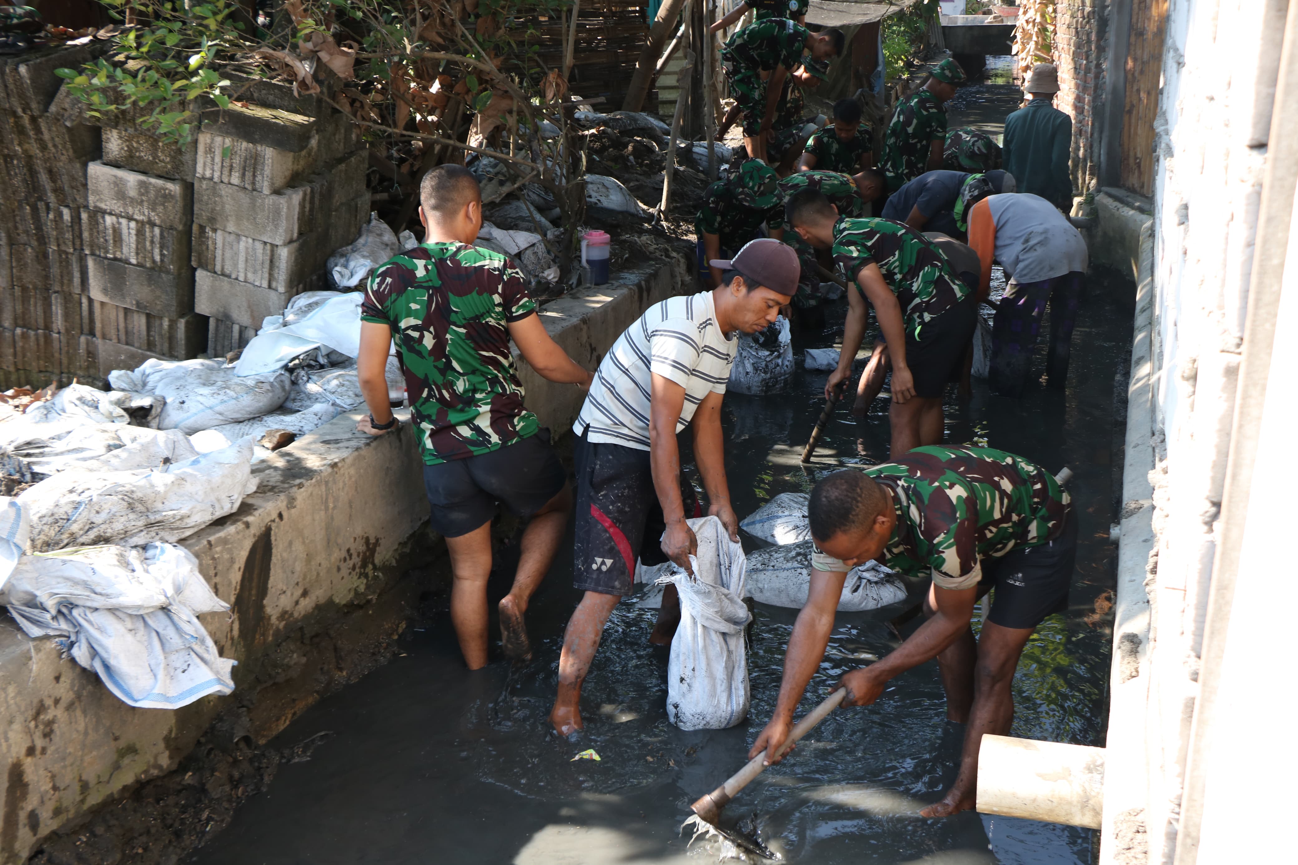 IST GOTONG ROYONG : TNI bersama dengan warga bersih-bersih sungai di Desa Penambangan, Balongbendo, Minggu (12/5). (IST)