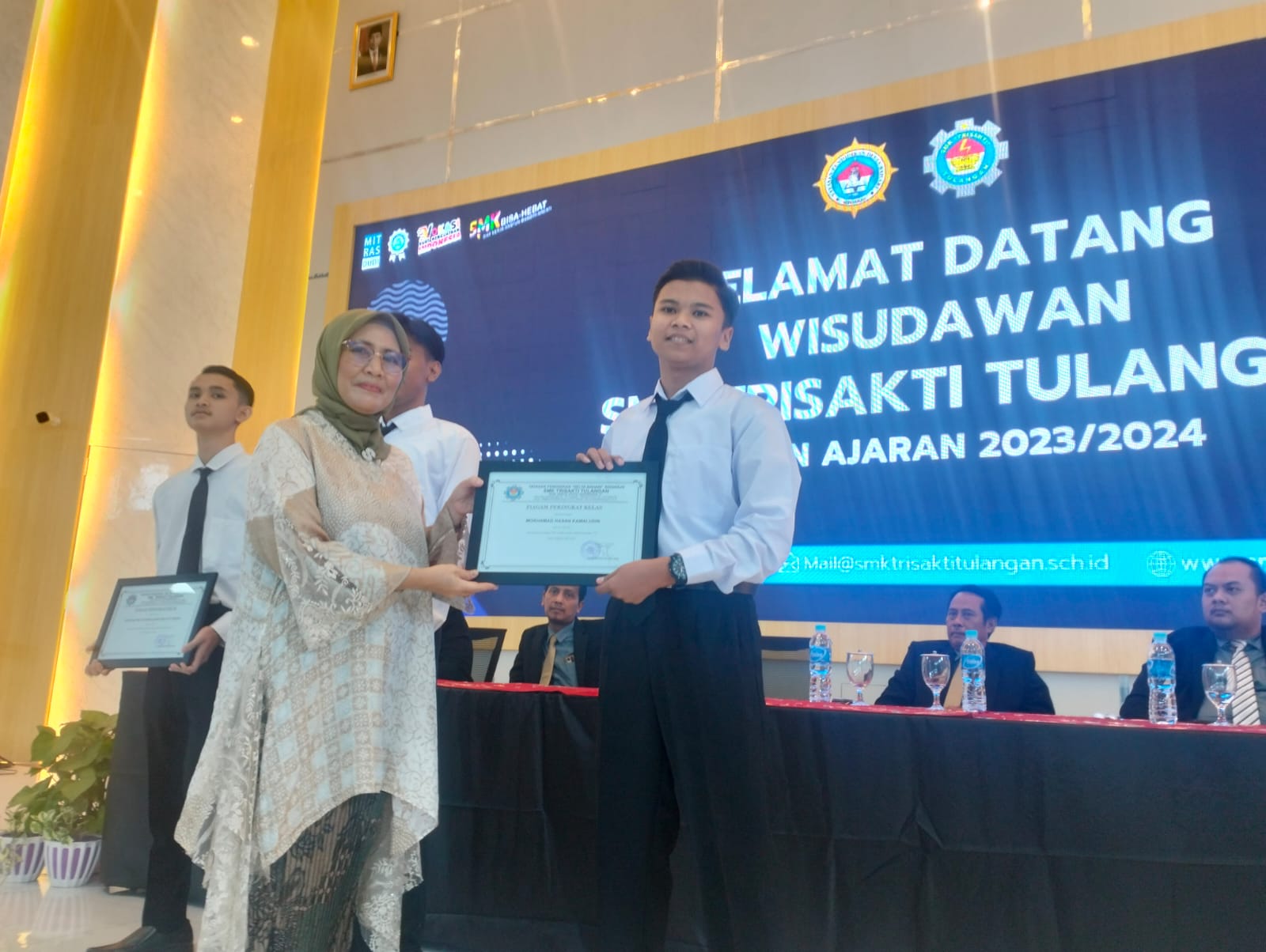 BANGGA: Kepala SMK Trisakti Tulangan Sulis Setiawati memberikan piagam kepada siswa berprestasi. (ANAS/RADAR SIDOARJO)