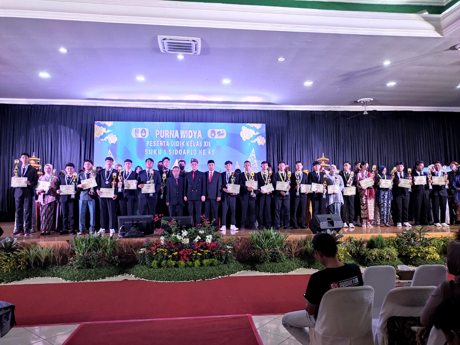 APRESIASI : Kepala SMK Negeri 1 Sidoarjo Dhanu Lukmantoro (pakai udeng) usai memberikan trophy dan piagam penghargaan kepada peserta didik berprestasi di setiap kompetensi keahlian.