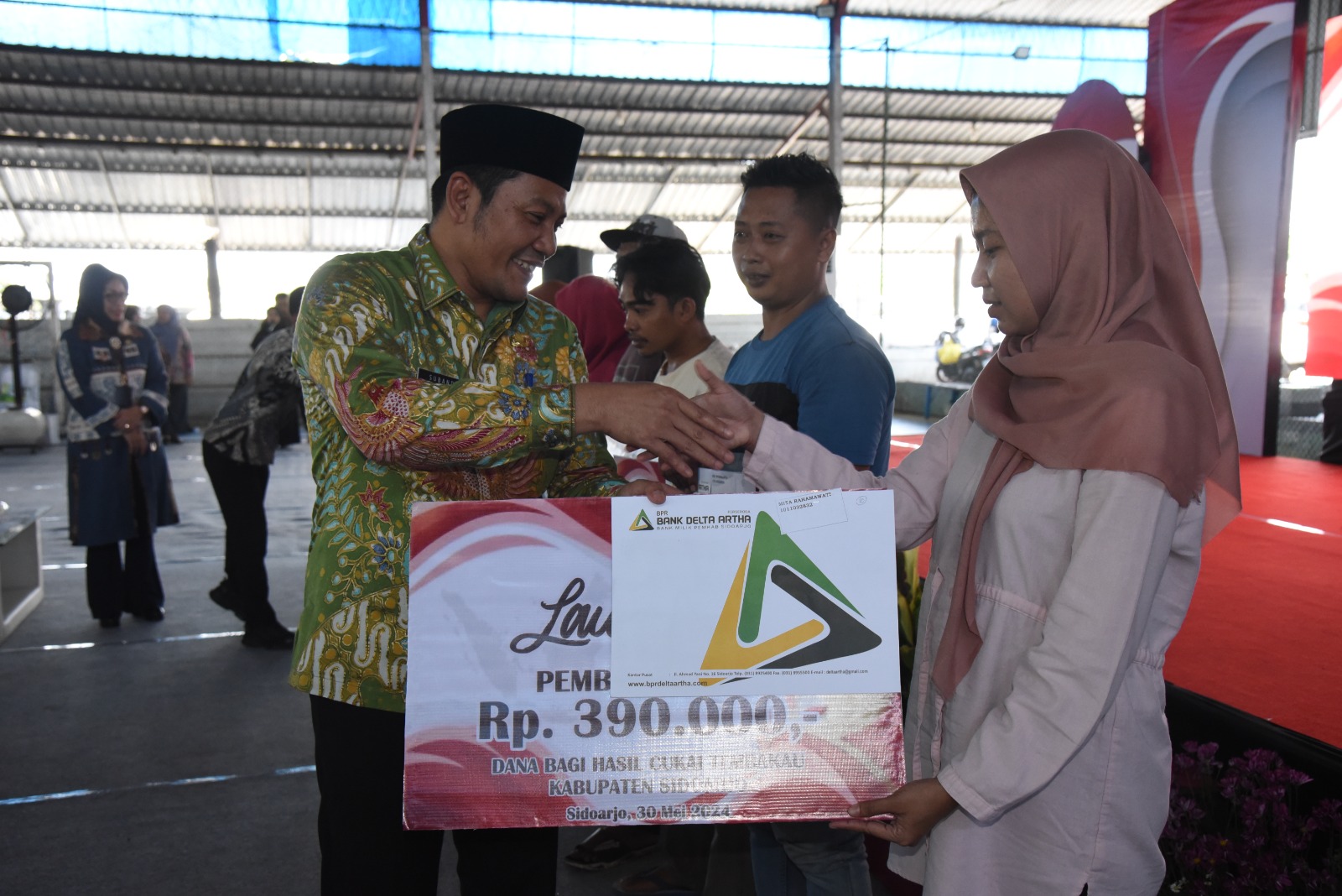 SIMBOLIS: Plt Bupati Sidoarjo Subandi serahkan Bantuan Langsung Tunai (BLT) ke buruh pabrik rokok. (M SAIFUL ROHMAN/RADAR SIDOARJO)