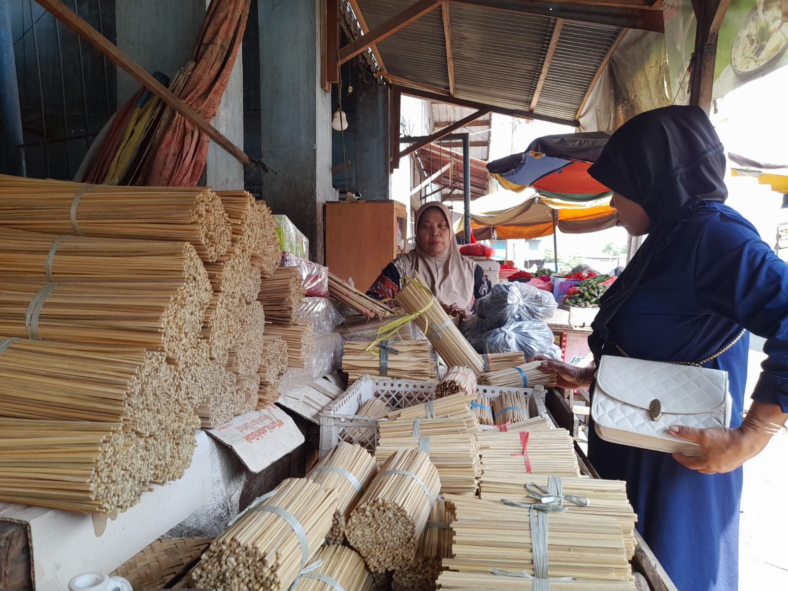 LARIS MANIS: Penjual tusuk sate Siti Aisyah saat meladeni pembeli. (M SAIFUL ROHMAN/RADAR SIDOARJO)
