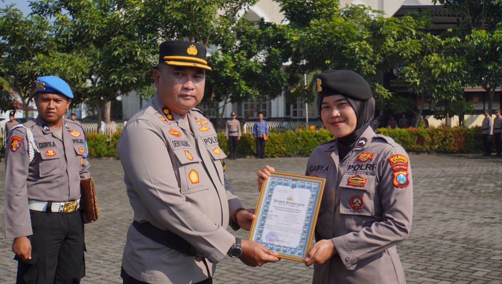 APRESIASI : Wakapolresta Sidoarjo AKBP Deny Agung Andriana serahkan penghargaan kepada Sat Samapta Polresta Sidoarjo Bripda Gaby Dara Ayu Salsabillah, Rabu (19/6). (DIKY PUTRA SANSIRI/RADAR SIDOARJO)