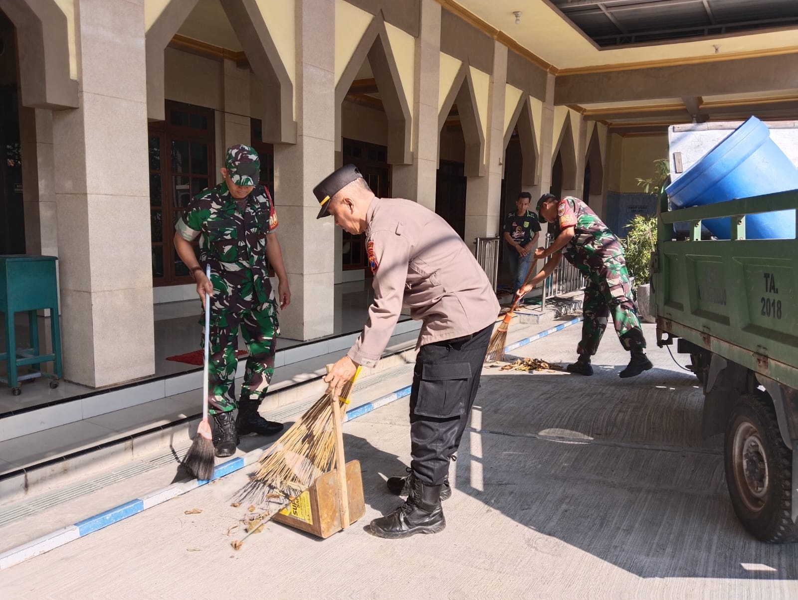 GOTONG ROYONG : Polisi dan TNI membersihkan Masjid Nurul Huda, Kamis (20/6). (IST)