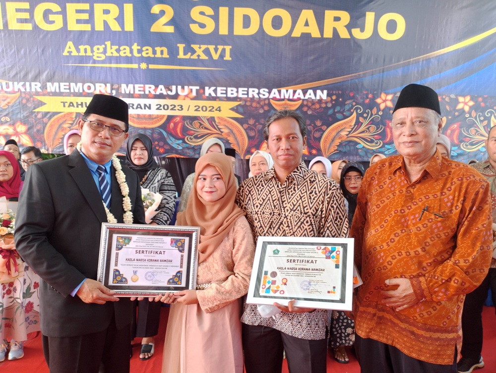 PRESTASI GEMILANG: Kaila Nadia Kirana Hamzah siswi kelas IX-A saat menerima apresiasi dan penghargaan dari Kepala SMP Negeri 2 Sidoarjo Drs. Qodim M.Si. sebagai murid berprestasi bidang akademik.