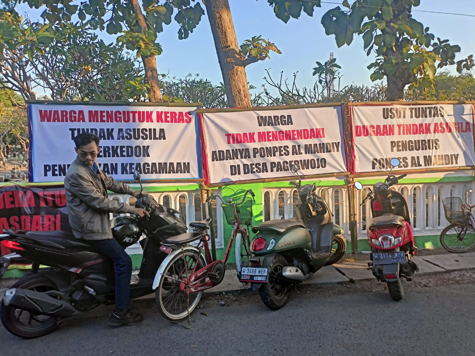 TIDAK TERIMA: Warga RT 20/RW 05 pasang puluhan spanduk di depan Ponpes Al Mahdiy. (DIKY PUTRA SANSIRI/RADAR SIDOARJO)