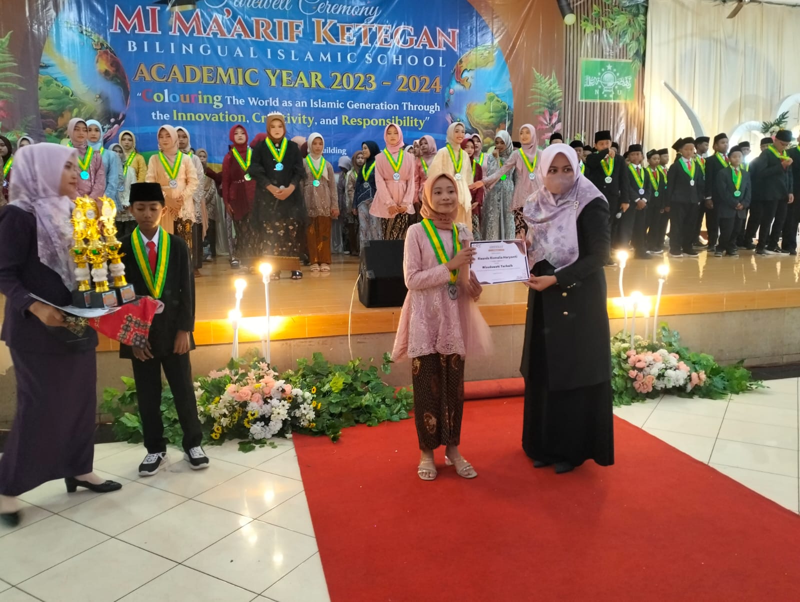 BANGGA: Kepala Ml Maarif Ketegan Bilingual Islamic School Umi Salamah memberikan penghargaane kepada siswa berprestasi. (ANAS/RADAR SIDOARJO