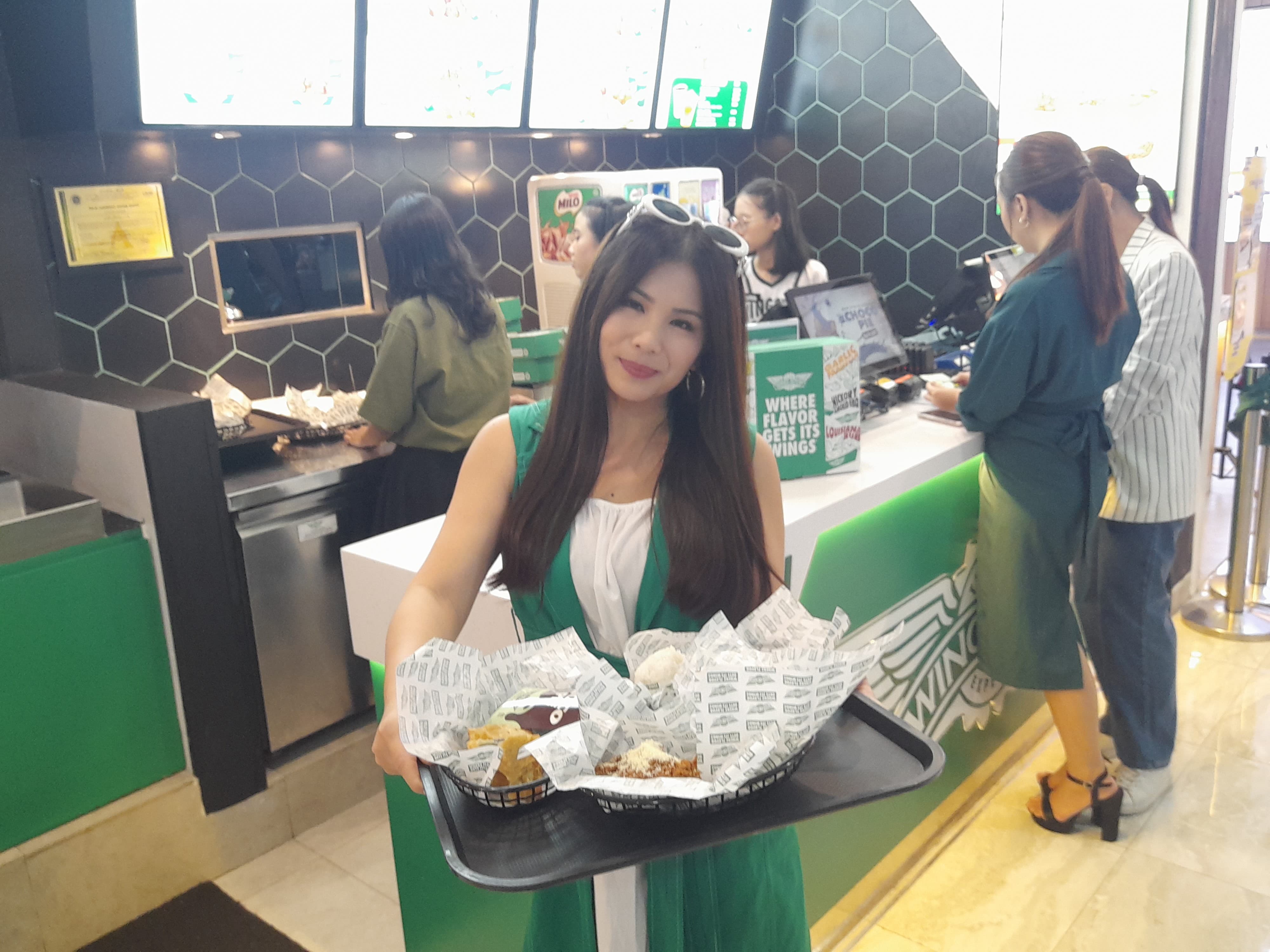 MENGGIURKAN: Pelanggan membawa menu pesanan Wingstop. (M SAIFUL ROHMAN/RADAR SIDOARJO)