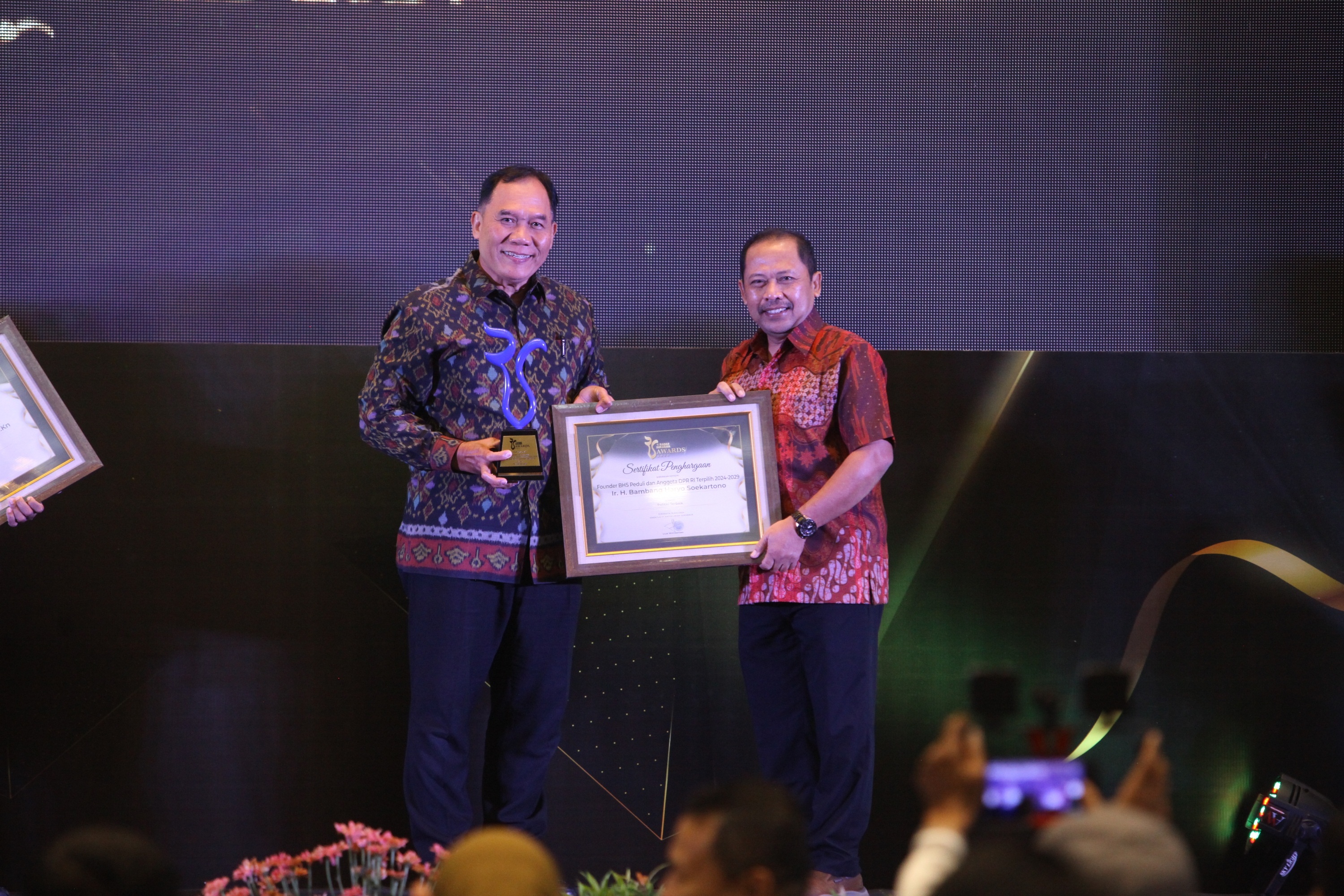 POLITISI TERBAIK: Ir H Bambang Haryo Soekartono saat menerima penghargaan Radar Surabaya Awards 2024 yang diserahkan oleh Direktur Radar Surabaya Lilik Widyantoro. (ANDY SATRIA/RADAR SURABAYA)