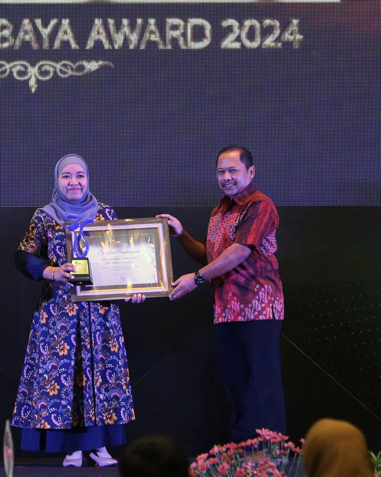 TERBIAK : Wakil Direktur RSI Siti Hajar Sidoarjo Hj. Alfi Rosidah, SE mendapatkan pengharagaan yang diserahkan Direktur Radar Surabaya Lilik Widyantoro. (ANDY SATRIA/RADAR SURABAYA)