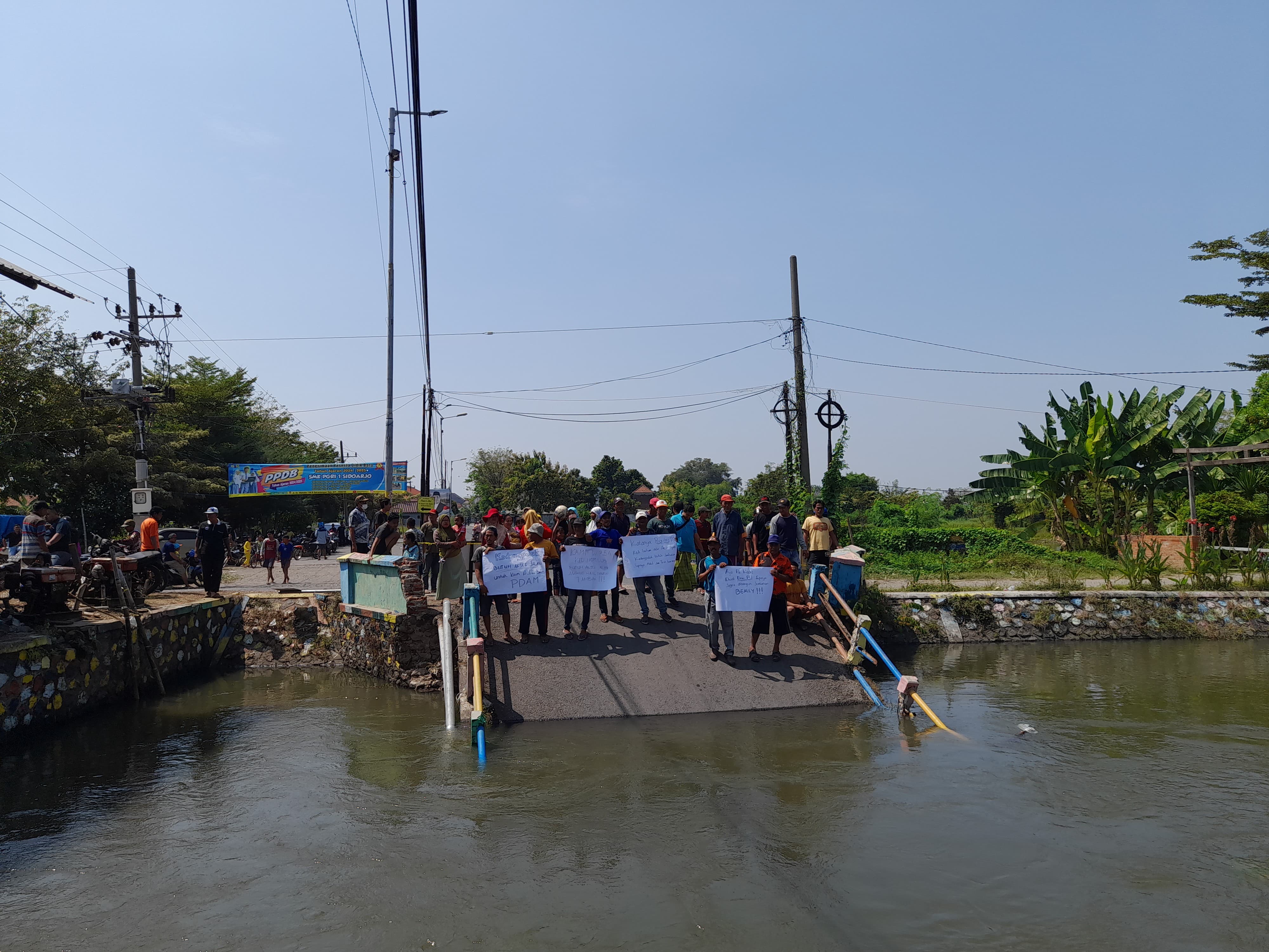 BUTUH SOLUSI : Puluhan warga Desa Kedungpeluk lakukan aksi unjukrasa di lokasi ambruknya jembatan. (M SAIFUL ROHMAN/RADAR SIDOARJO)
