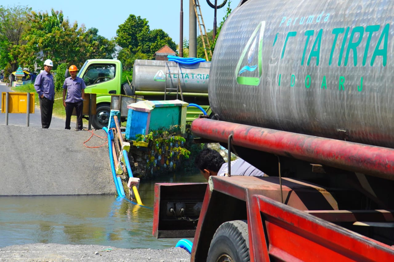 SOLUSI : Truk tangki Perumda Delta Tirta menyalurkan air bersih ke warga yang terisolir di Desa Kedungpeluk, Kecamatan Candi. (IST)