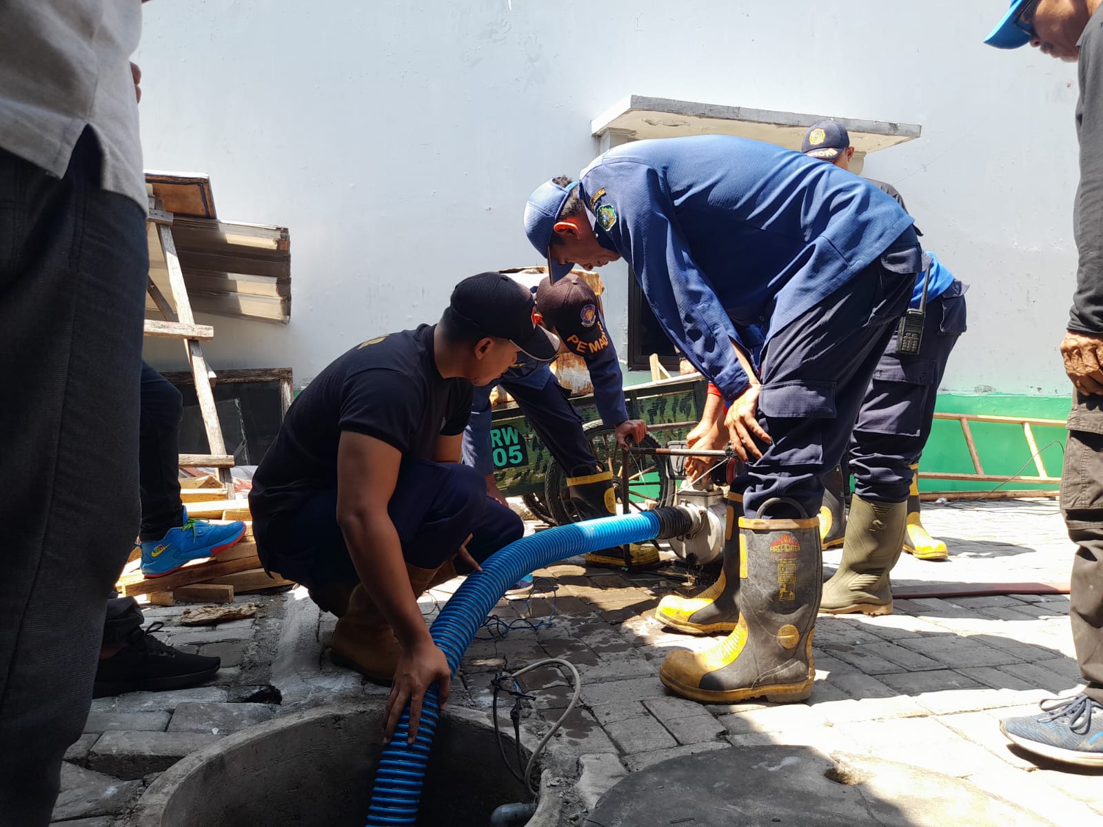 SUDAH AMAN : Petugas dari Damkar BPBD Sidoarjo saat lakukan pengurasan. (M SAIFUL ROHMAN/RADAR SIDOARJO)