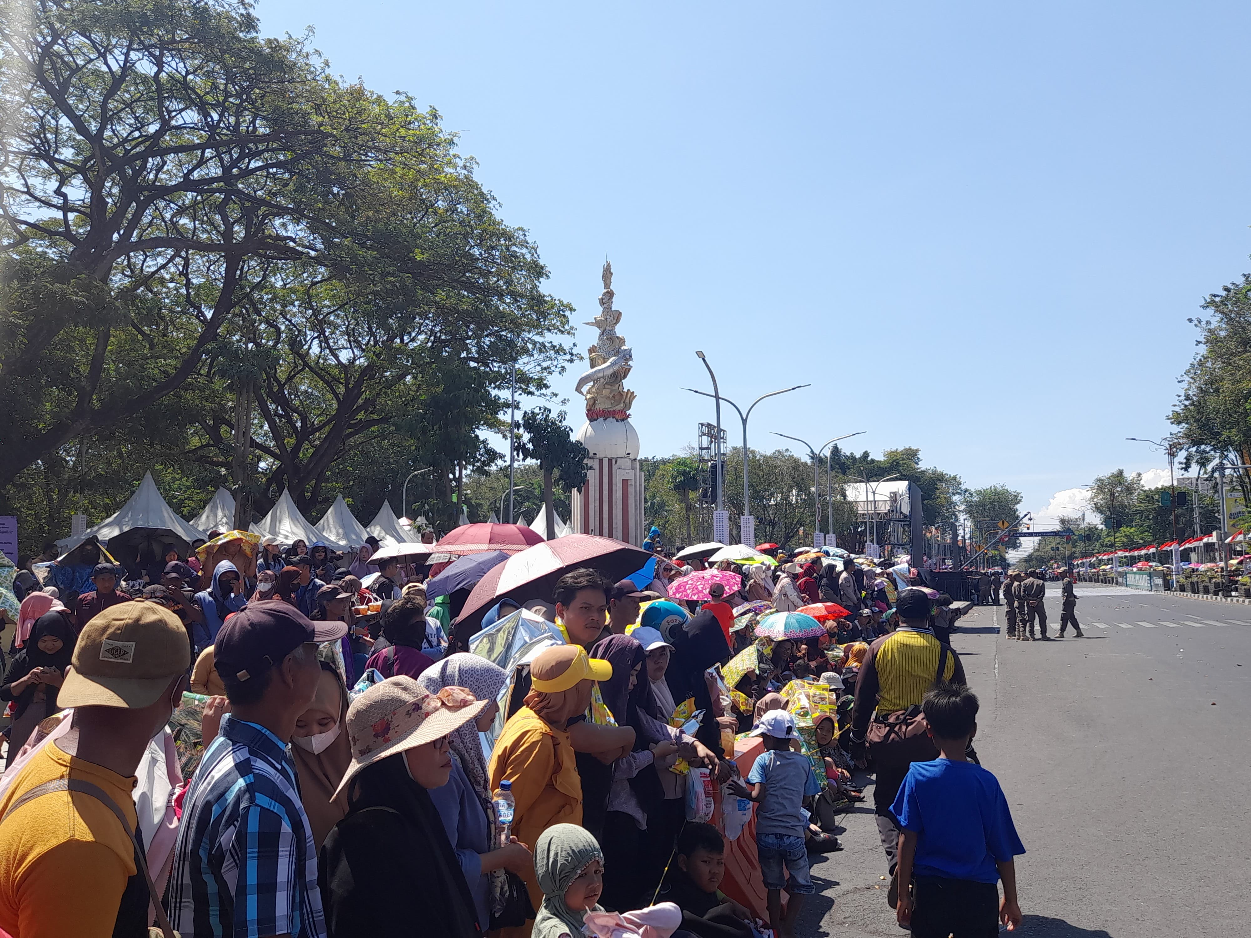 MEMBELUDAK : Warga antusias menyaksikan karnaval di depan patung Jayandaru. (M SAIFUL ROHMAN/RADAR SIDOARJO)