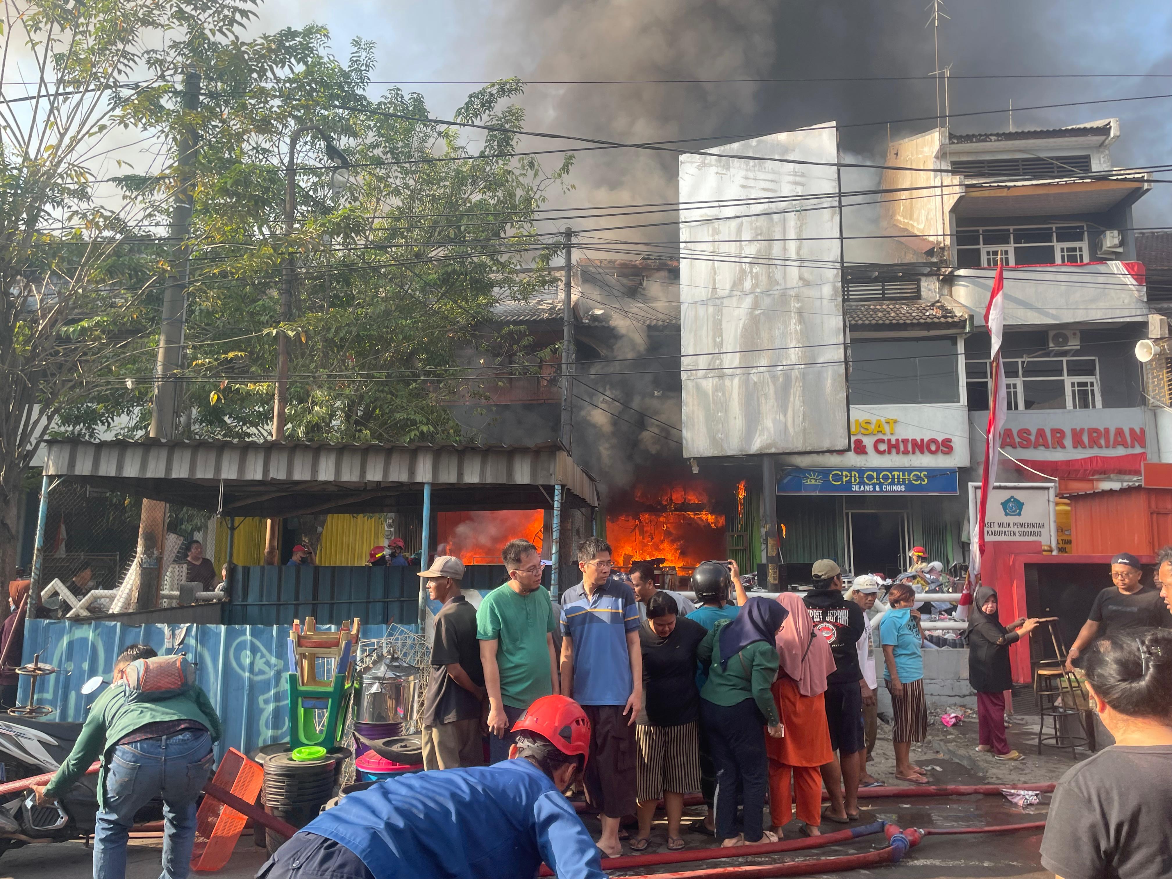 MEMBARA : Petugas damkar berjibaku memadamkan api di Pasar Krian, Selasa (20/8). (DIKY PUTRA SANSIRI/RADAR SIDOARJO)