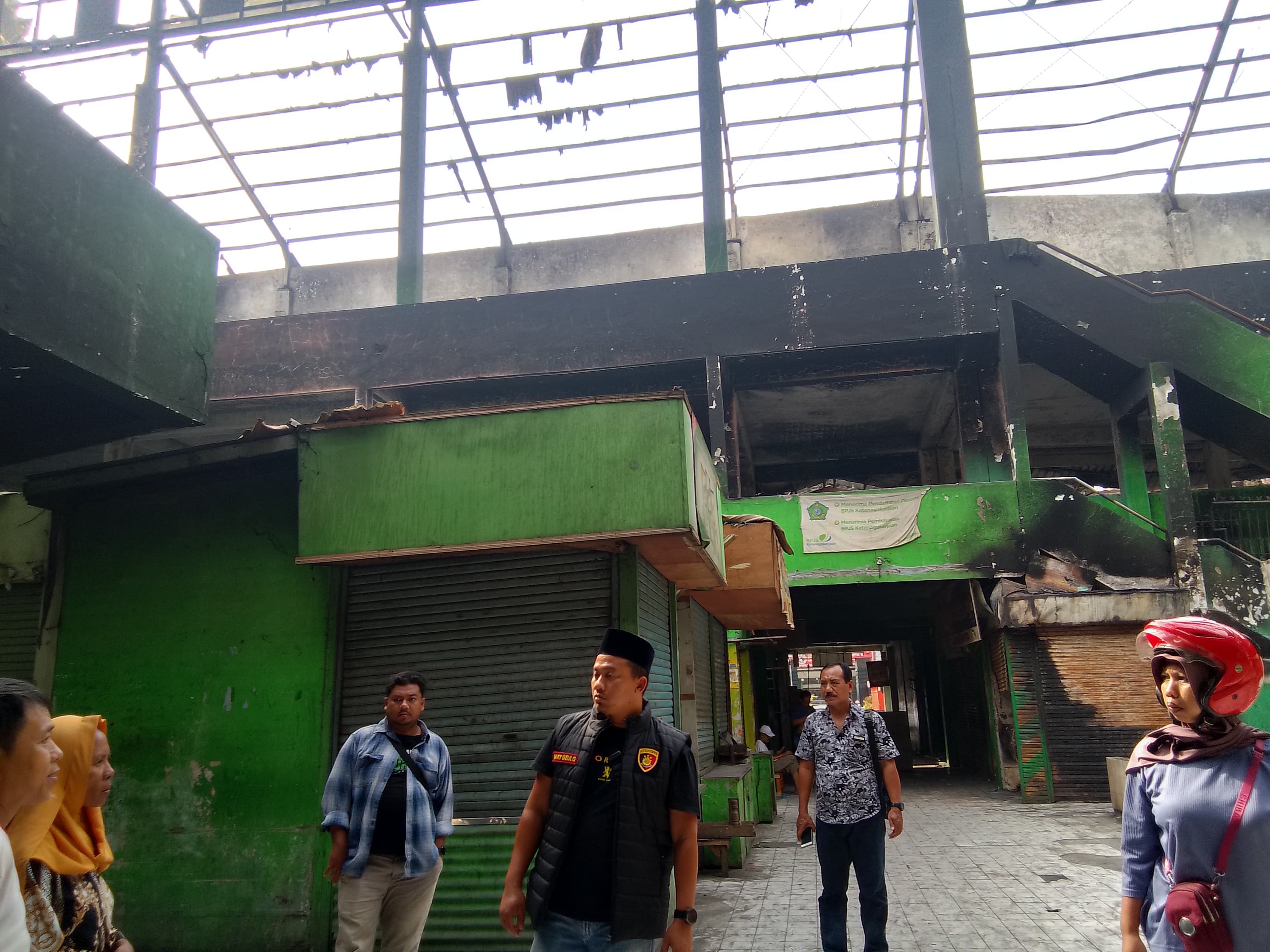 PERKETAT KEAMANAN : Kapolsek Krian Kompol Daky Dzul Qornain (tengah) berkoordinasi dengan petugas PLN mengecek kondisi Pasar Krian pasca kebakaran, Kamis (22/8). (DIKY PUTRA SANSIRI/RADAR SIDOARJO)