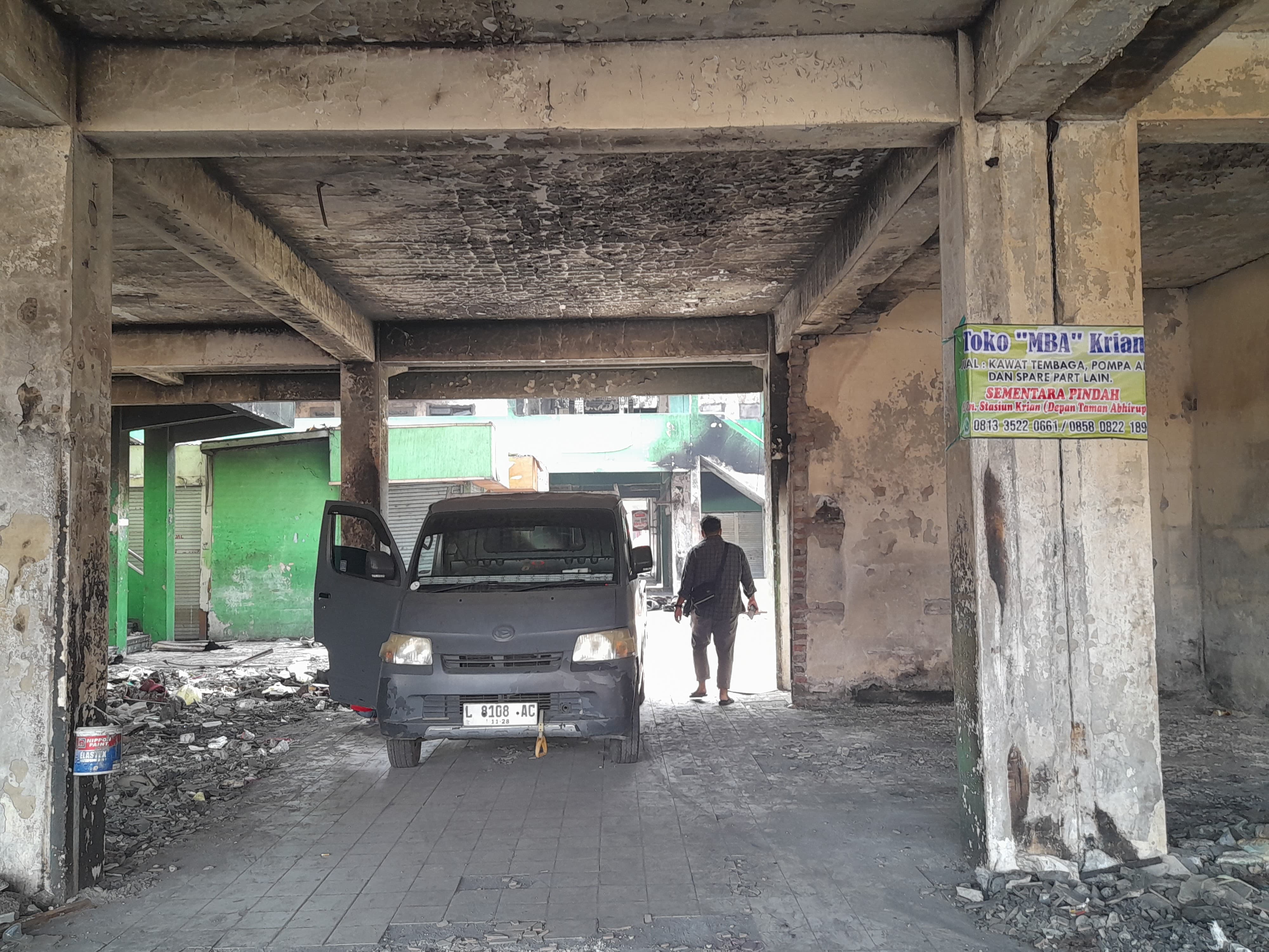 LUDES : Pedagang Pasar Krian memasang banner pengumuman pindah tempat sementara. (M SAIFUL ROHMAN/RADAR SIDOARJO)