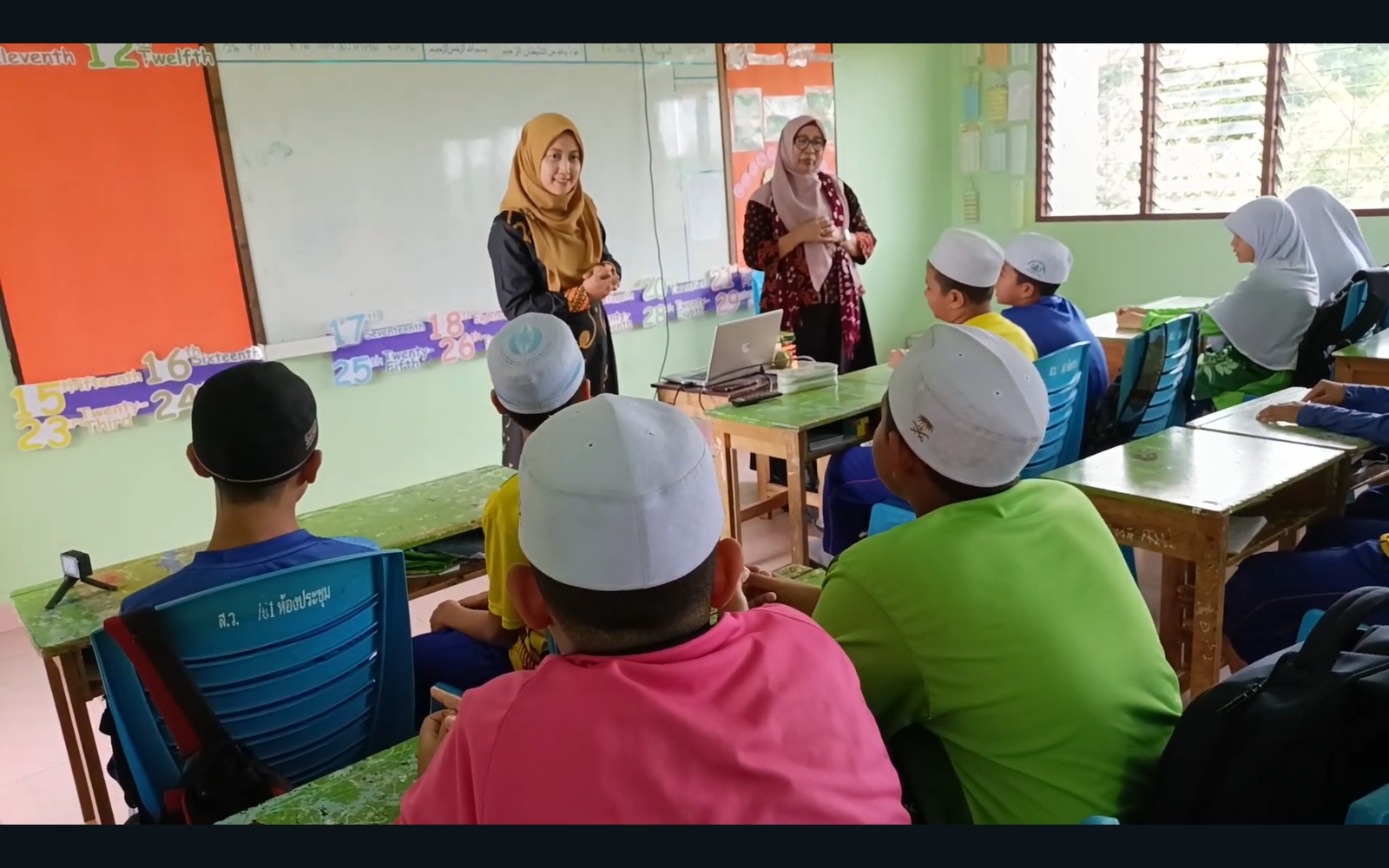 BERMANFAAT : Dosen PBI sedang menjelaskan mengenai Stick Puppets dan cara membuatnya di Sangkhom Islam Wittaya School.