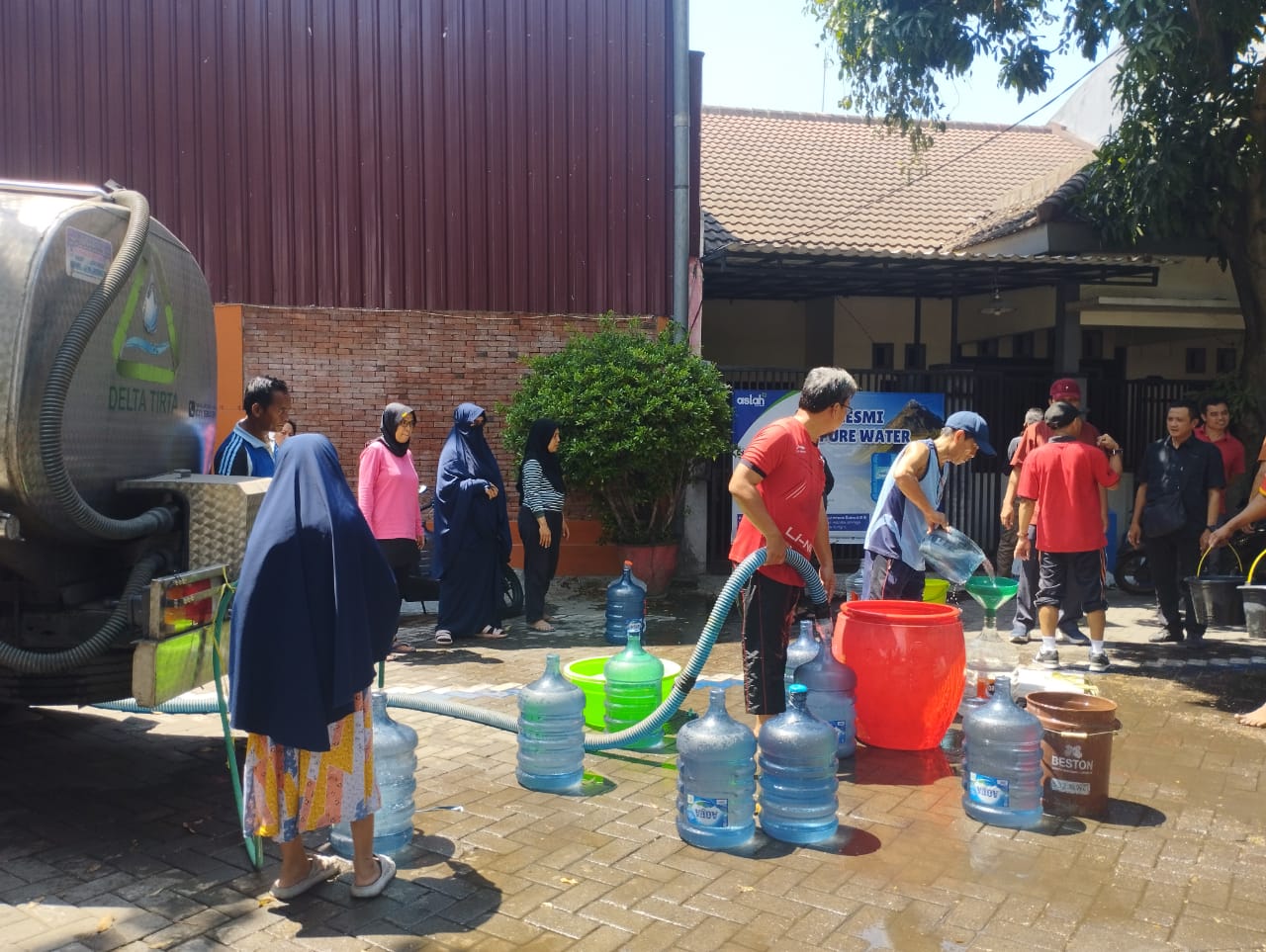 KEMARAU PANJANG: Petugas PDAM Sidoarjo saat distribusikan air bersih ke warga. (IST)