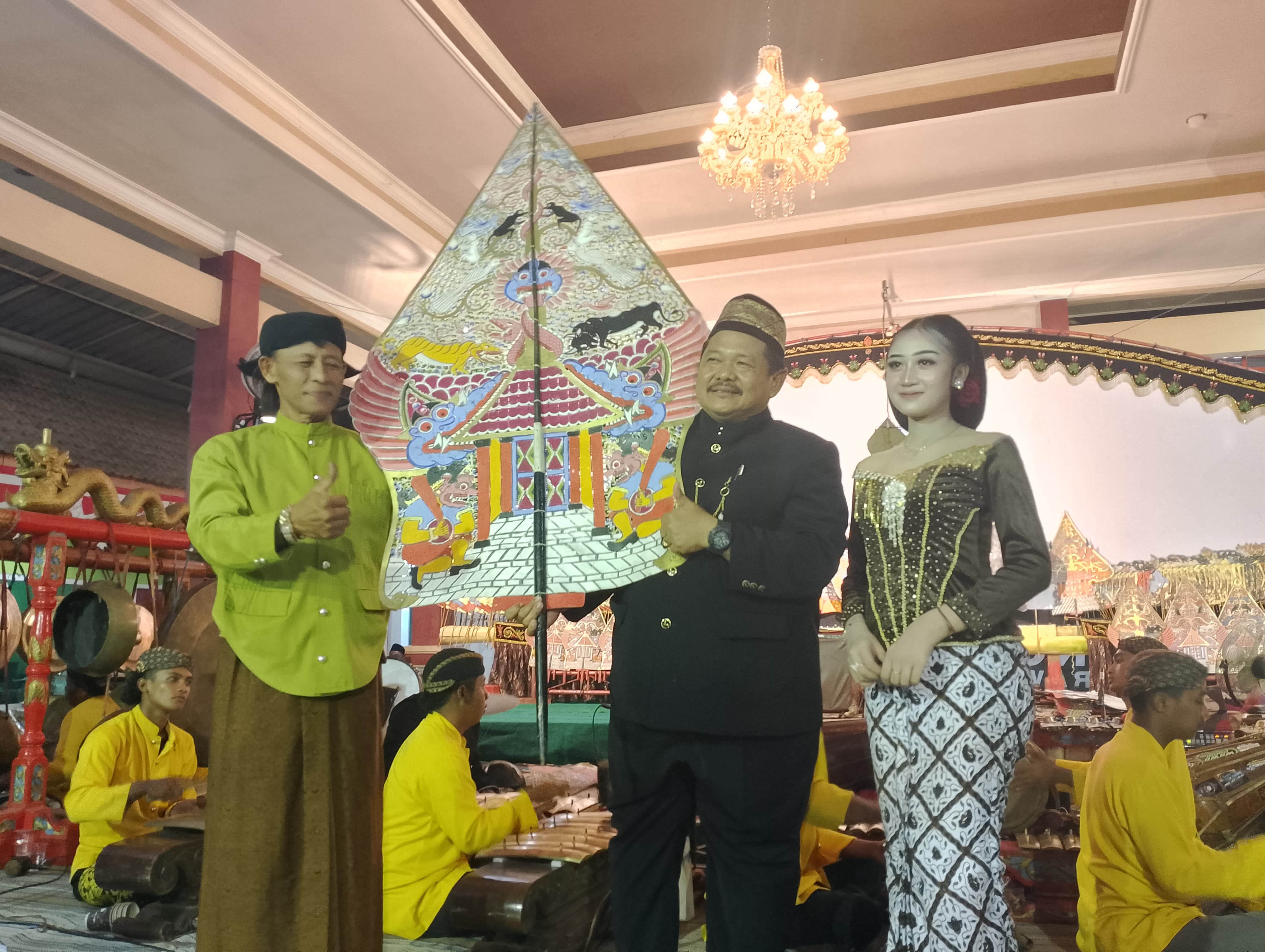 SIMBOLIS: Kepala Desa Semampir, Luqman Mualim SH menyerahkan gunungan wayang kepada Ki Anom Sudarmaji. (INDRA/RADAR SIDOARJO)