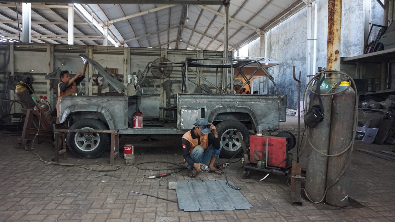 KREATIF: Pekerja saat melakukan modifikasi mobil bekas. (M SAIFUL ROHMAN/RADAR SIDOARJO)