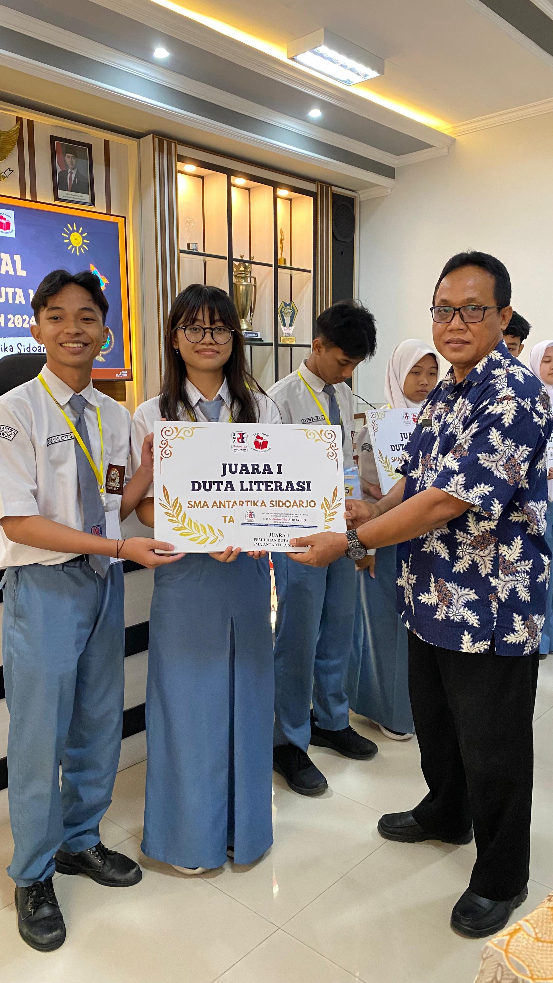 LUAR BIASA: Kepala SMA Antartika Sidoarjo Mudjaini Ahmad,S.Pd.,M.Pd. memberikan secara simbolis kepada juara 1 Duta Literasi, Jullyan Adyt Suritna berpasangan Nadia Putri Ardiyanti.